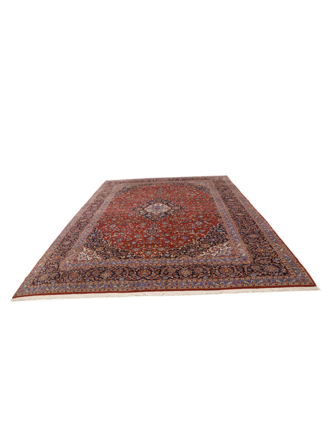 Een groot rechthoekig handgeknoopt Keshan-tapijt uit het Midden-Oosten met een rood veld en een ingewikkeld blauw en wit bloemenmedaillon.