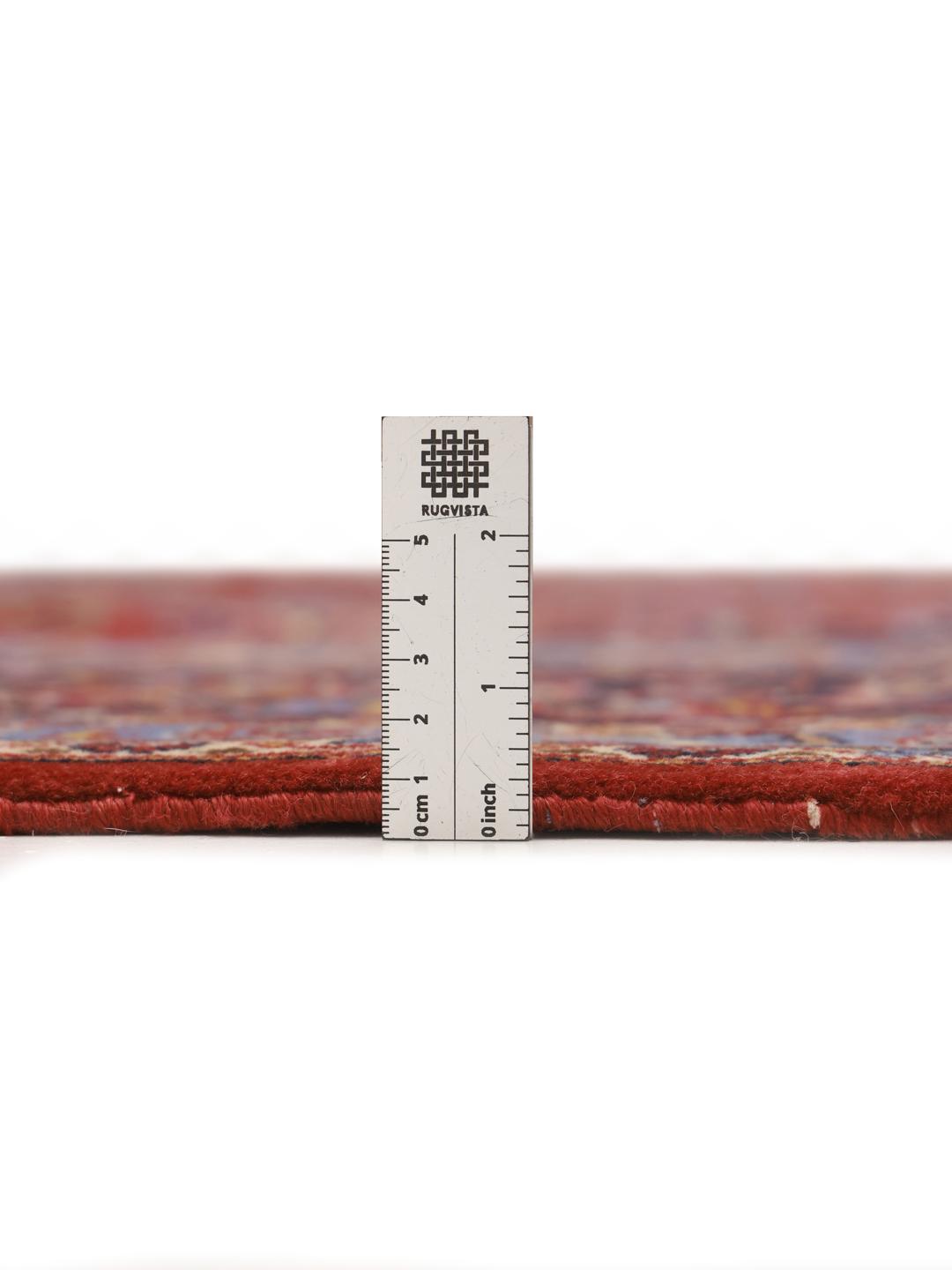 Een groot rechthoekig handgeknoopt Keshan-tapijt uit het Midden-Oosten met een rood veld en een ingewikkeld blauw en wit bloemenmedaillon.