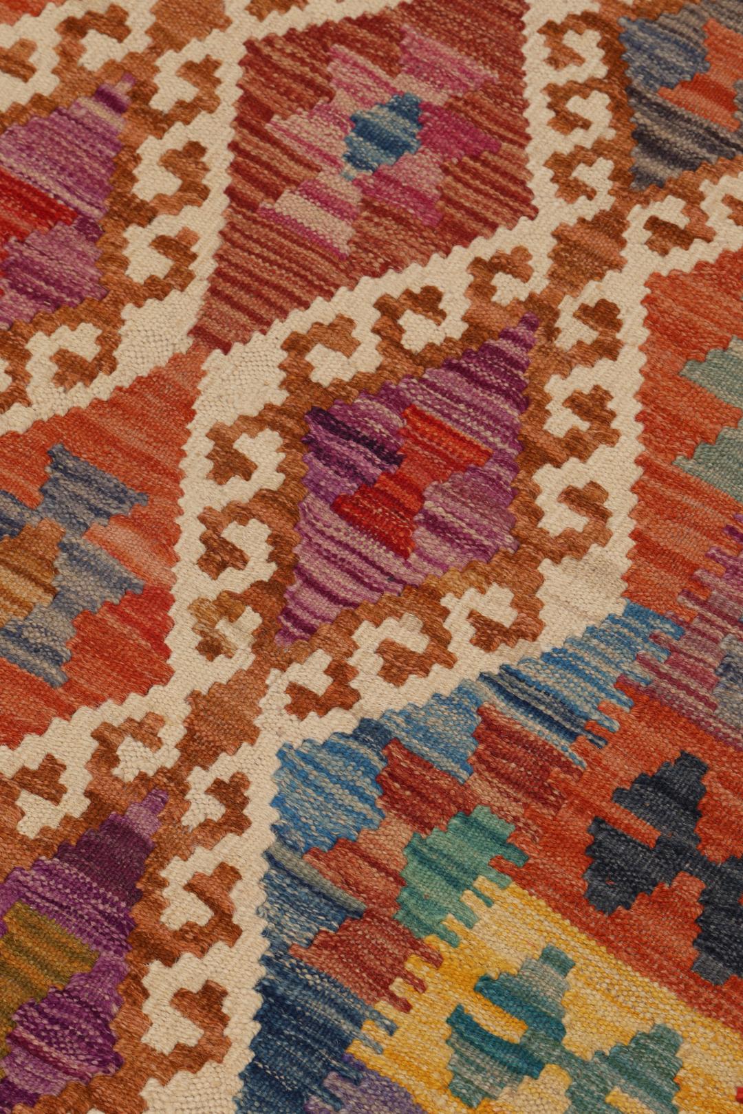 Hand-woven Afghan Kelim rug featuring a vibrant multicolor diamond geometric pattern