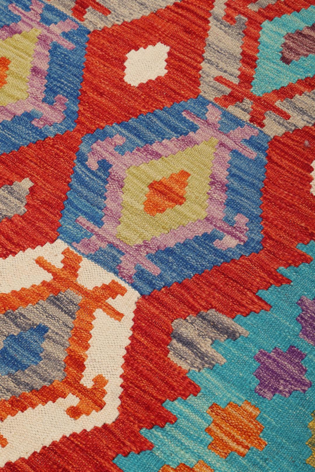 Handgeweven Afghan Kelim-tapijt met een levendig, meerkleurig geometrisch patroon.