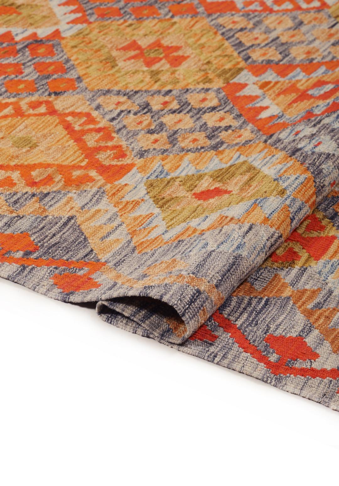 A rectangular Afghan Kelim rug featuring a vibrant geometric pattern in shades of orange, grey, and ochre.