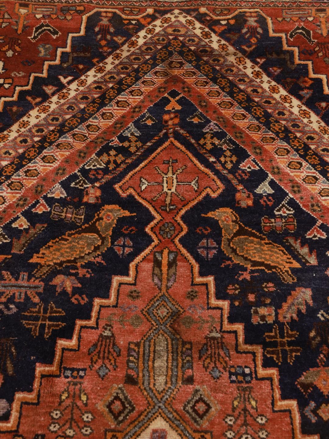 A unique, hand-knotted Qashqai rug from the Middle East featuring a bold multicolor diamond medallion.