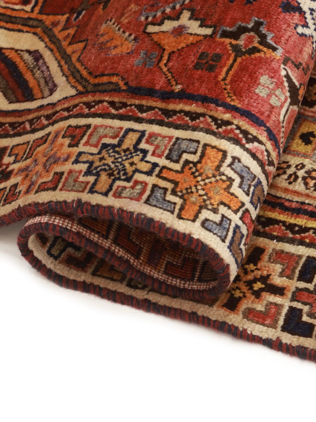 A unique, hand-knotted Qashqai rug from the Middle East featuring a bold multicolor diamond medallion.