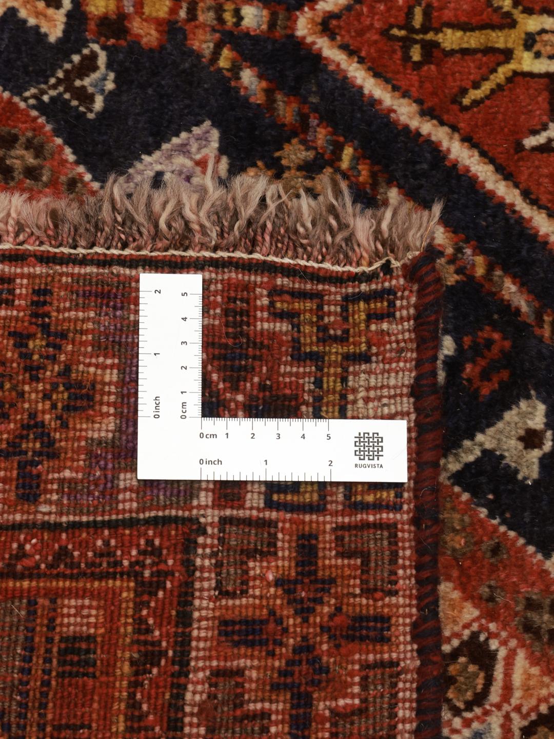 A unique, hand-knotted Qashqai rug from the Middle East featuring a bold multicolor diamond medallion.