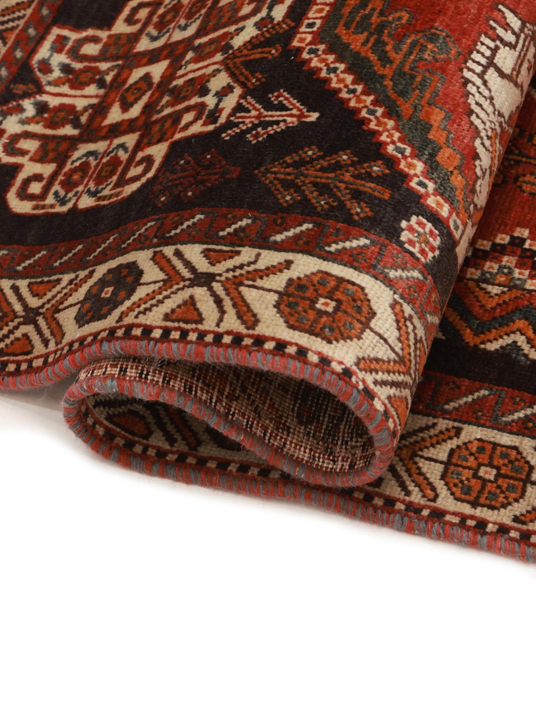 Hand-knotted Ghashghai rug from the Middle East featuring a red and black tribal pattern.