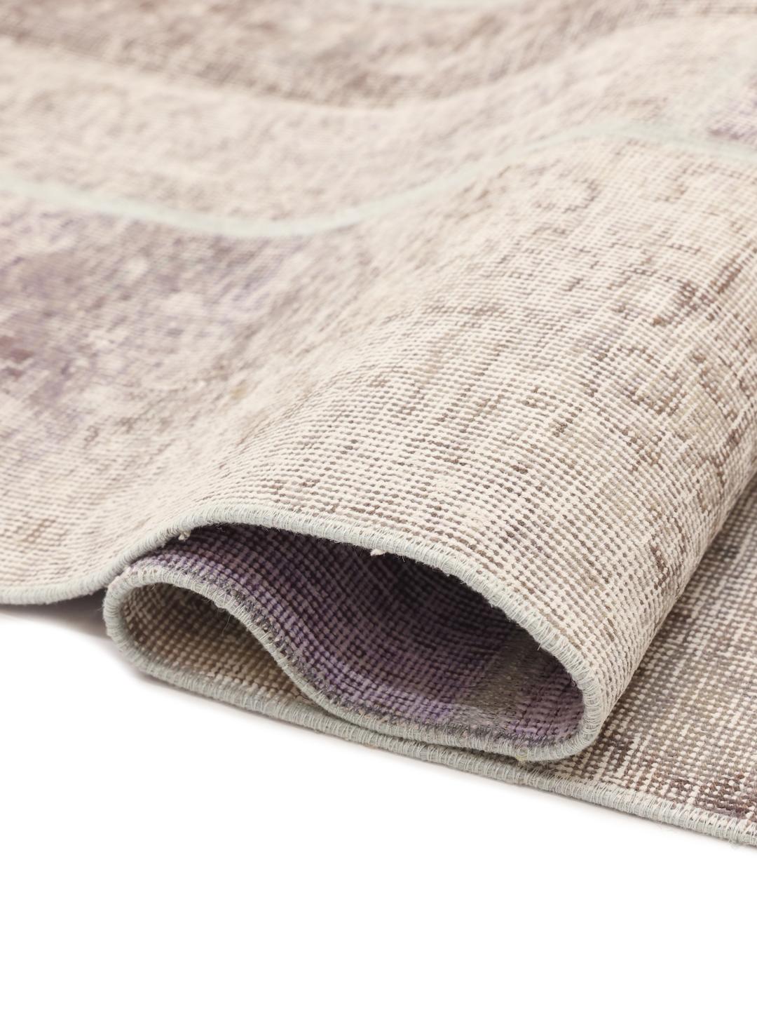 Et unikt patchwork-tæppe med lyse-lilla og neutrale toner, håndlavet i Mellemøsten.