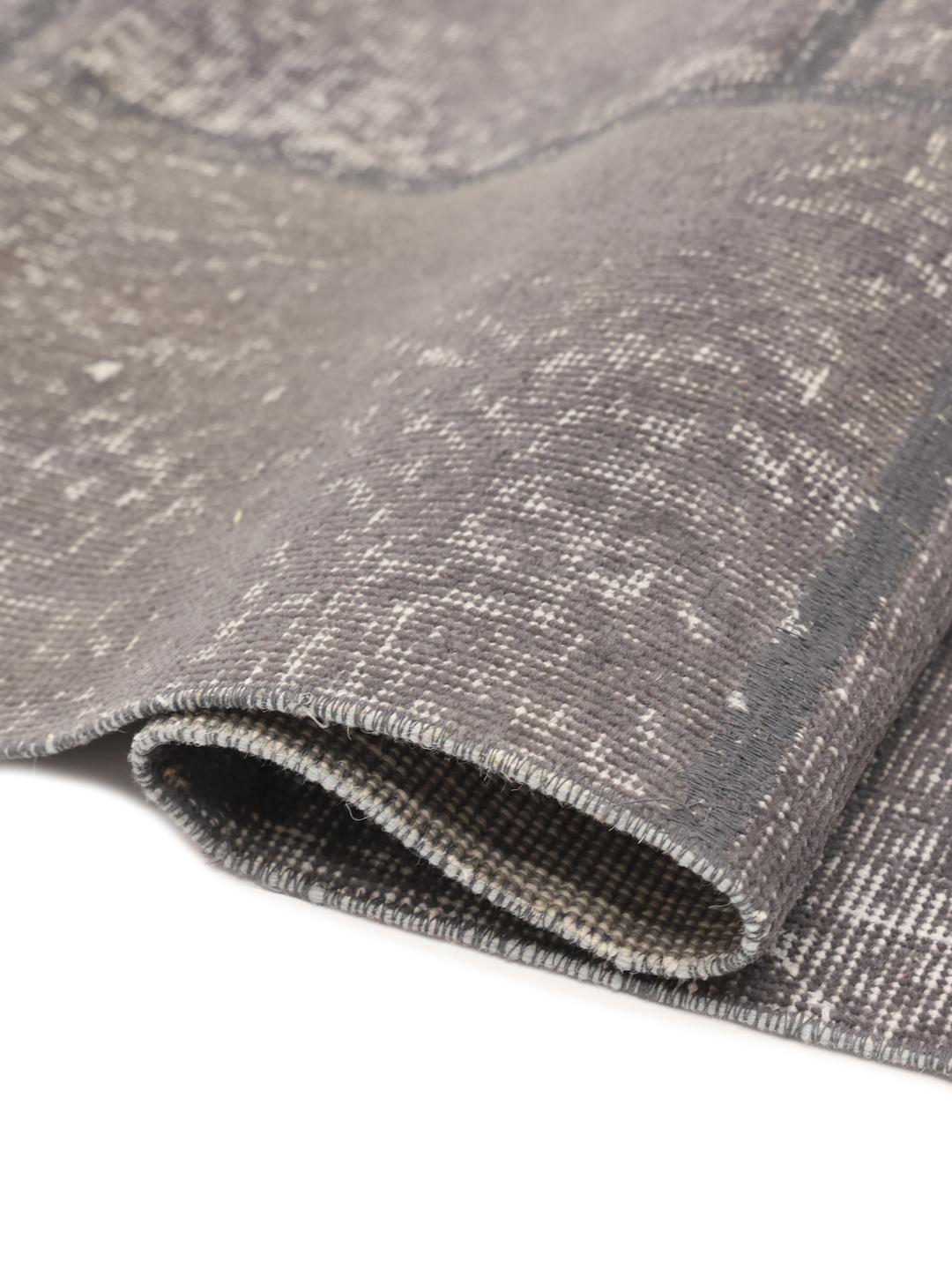 Et rektangulært patchwork-tæppe fra Mellemøsten i forskellige nuancer af mørkegrå.