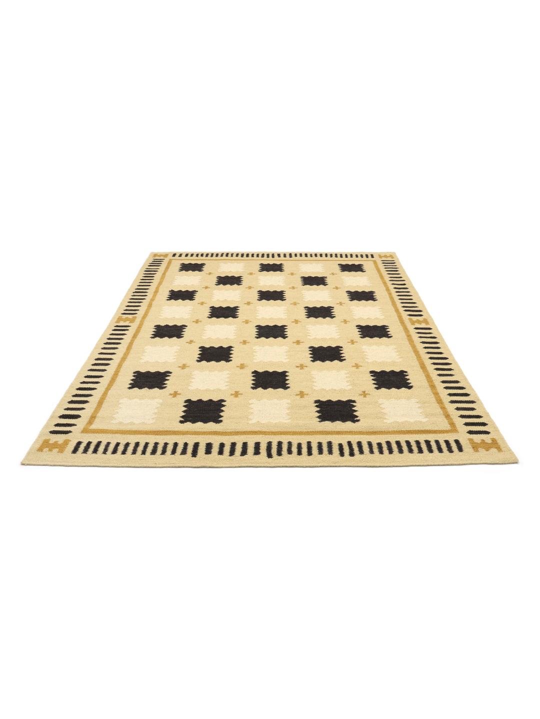 Een geel vloerkleed met een geometrisch patroon in zwarte en beige tinten.