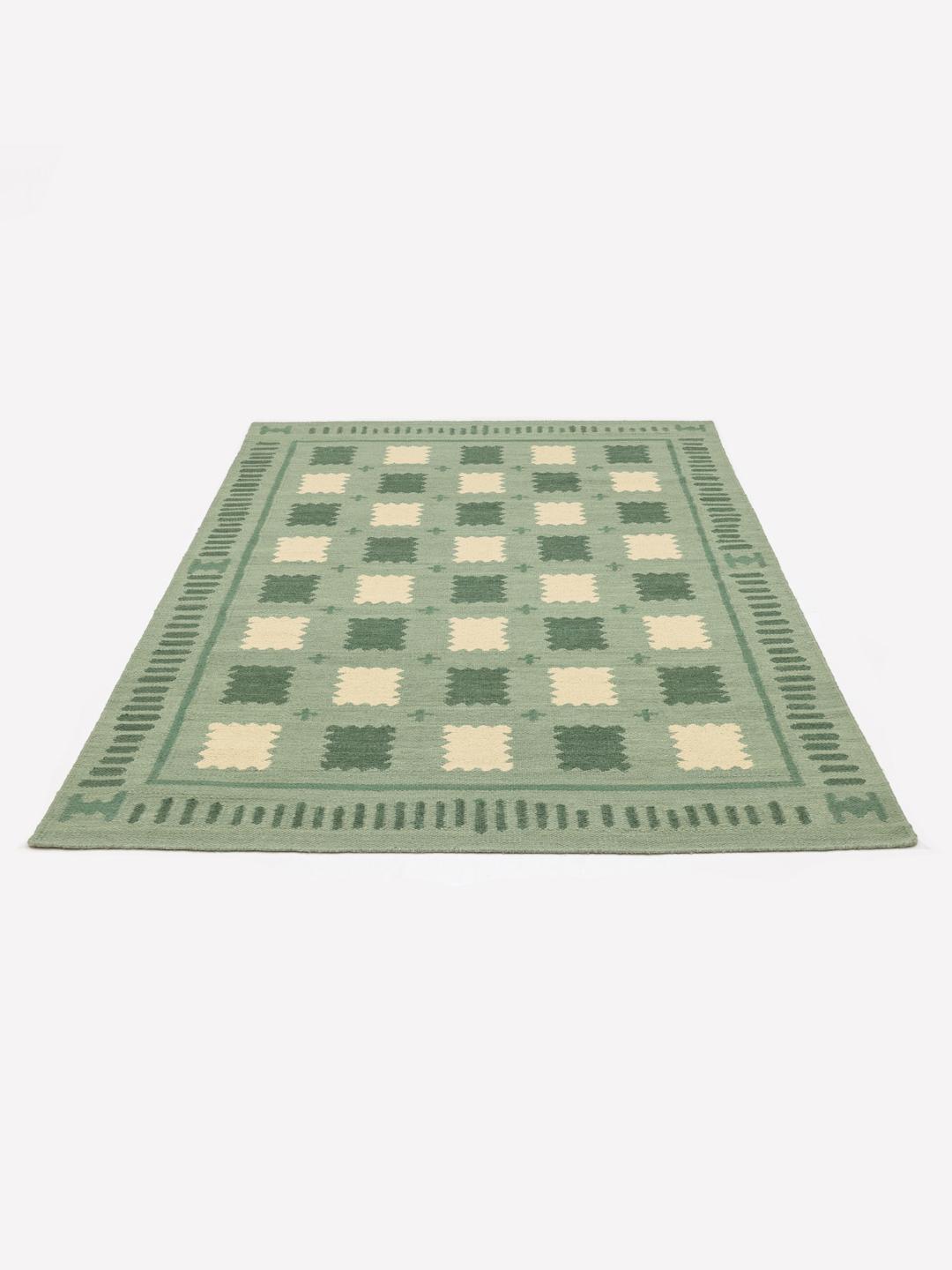 Handgeweven groen tapijt met een geometrisch patroon