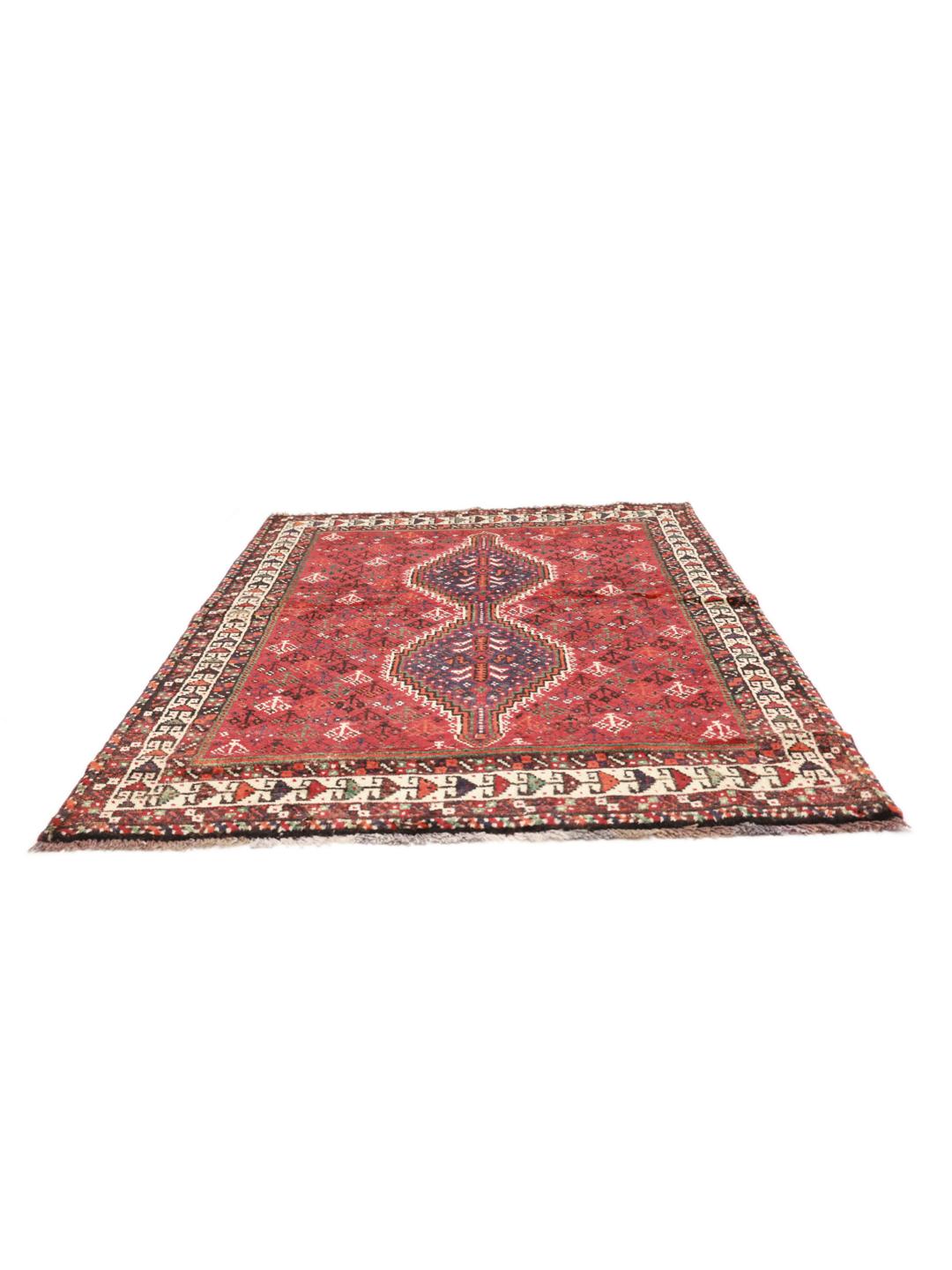 A hand-knotted Shiraz rug from the Middle East in deep red with geometric patterns.
