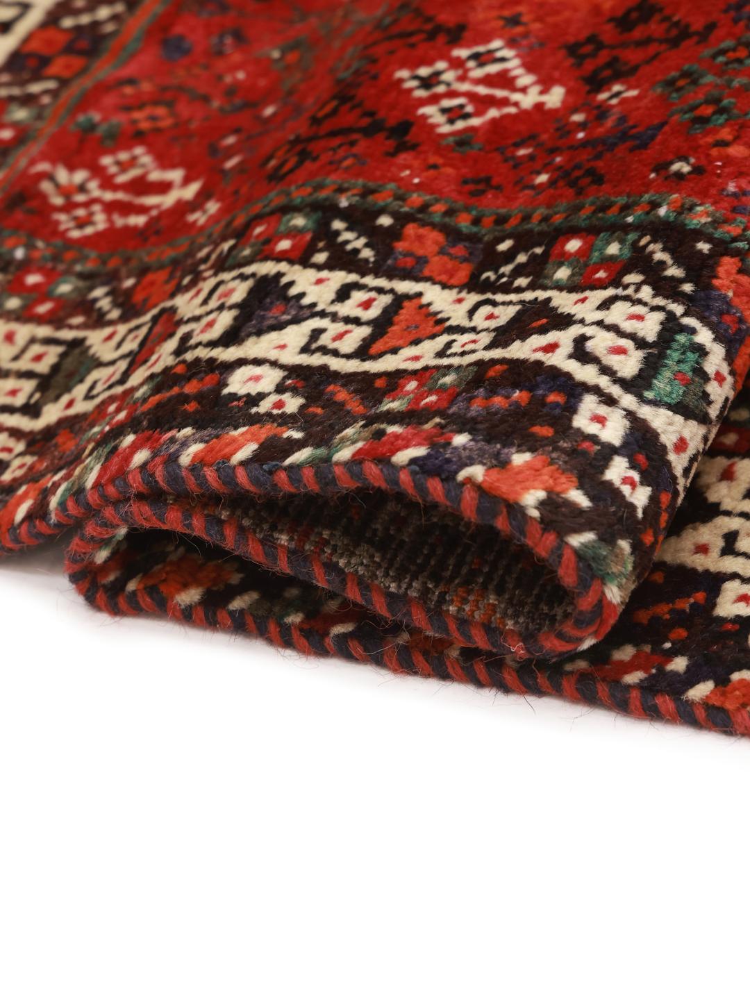 A hand-knotted Shiraz rug from the Middle East in deep red with geometric patterns.