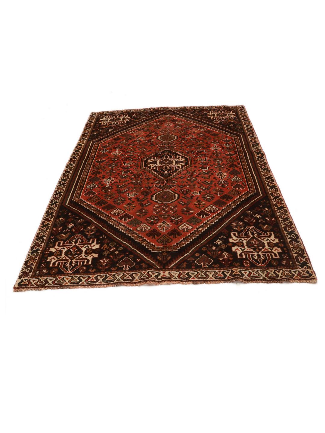 A hand-knotted Qashqai rug from the Middle East featuring a red field and decorative borders.
