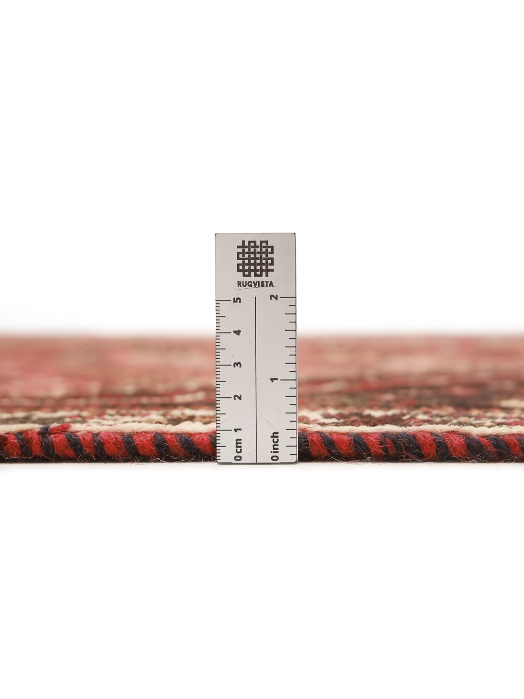 A hand-knotted Qashqai rug from the Middle East featuring a red field and decorative borders.