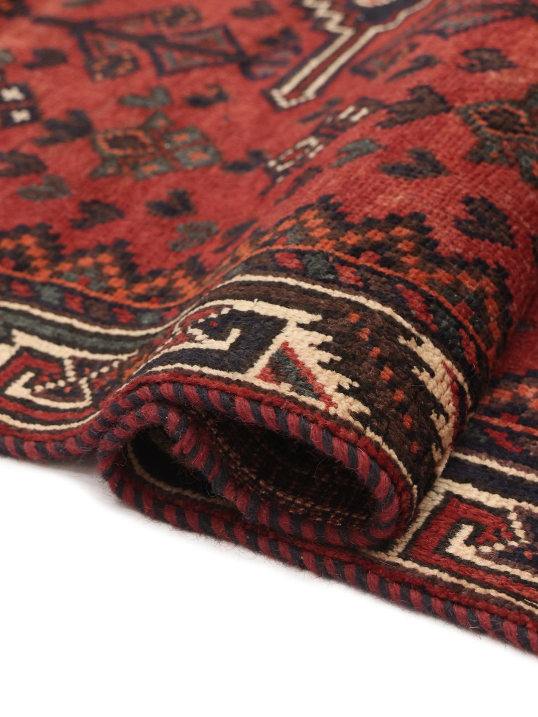 A hand-knotted Shiraz rug from the Middle East featuring geometric patterns in dark red and deep blue