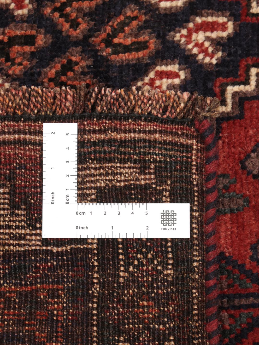 A hand-knotted Shiraz rug from the Middle East featuring geometric patterns in dark red and deep blue