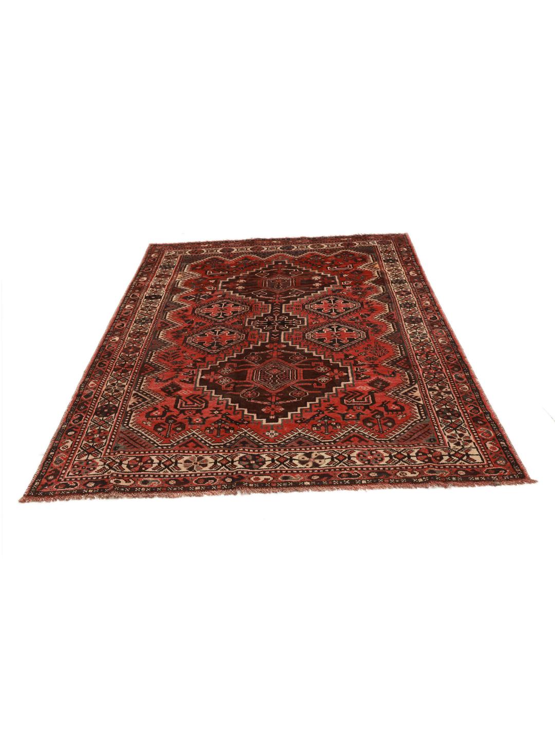 A hand-knotted Shiraz rug from the Middle East featuring geometric red patterns.