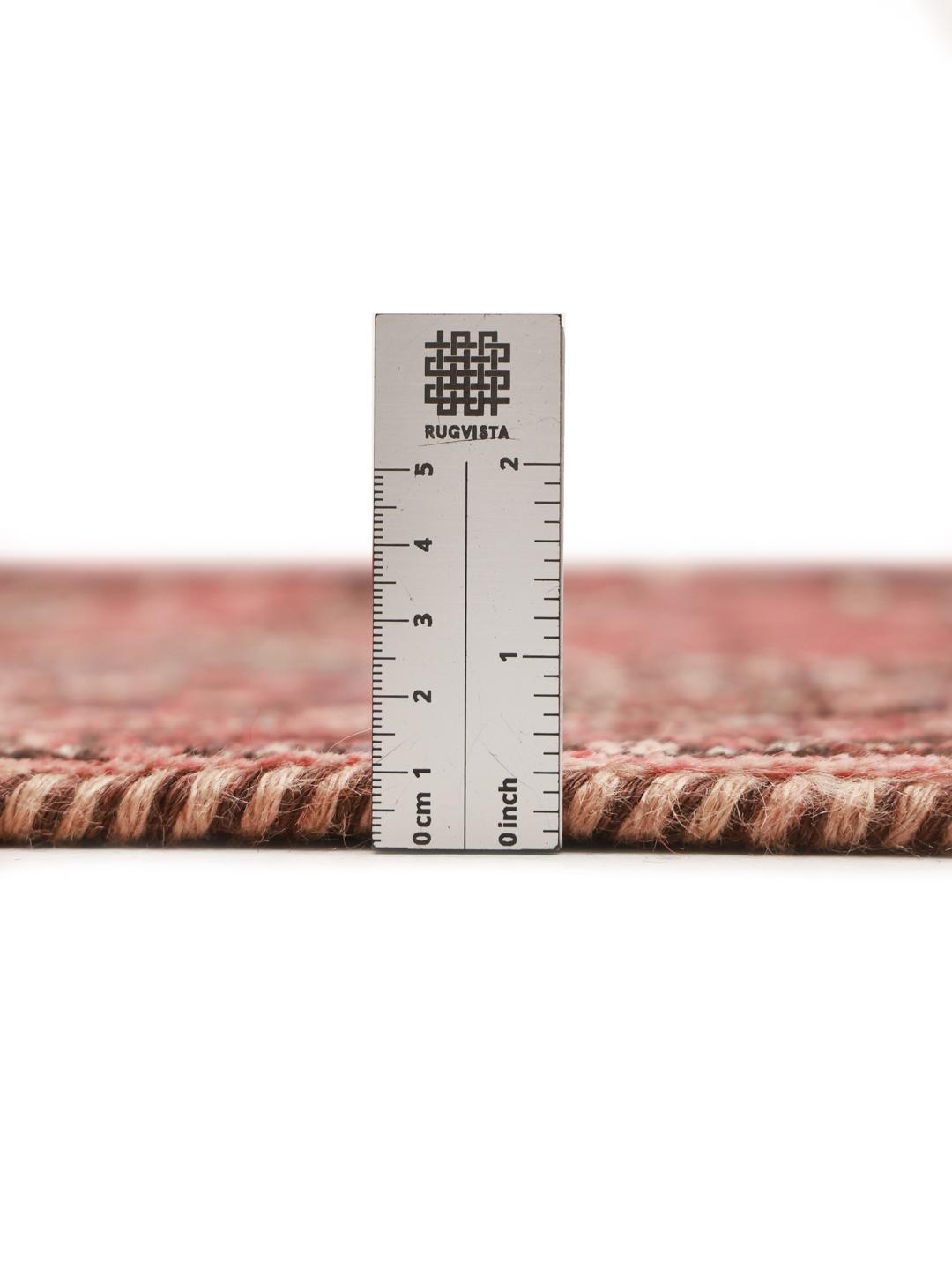 A hand-knotted Shiraz rug from the Middle East featuring geometric red patterns.