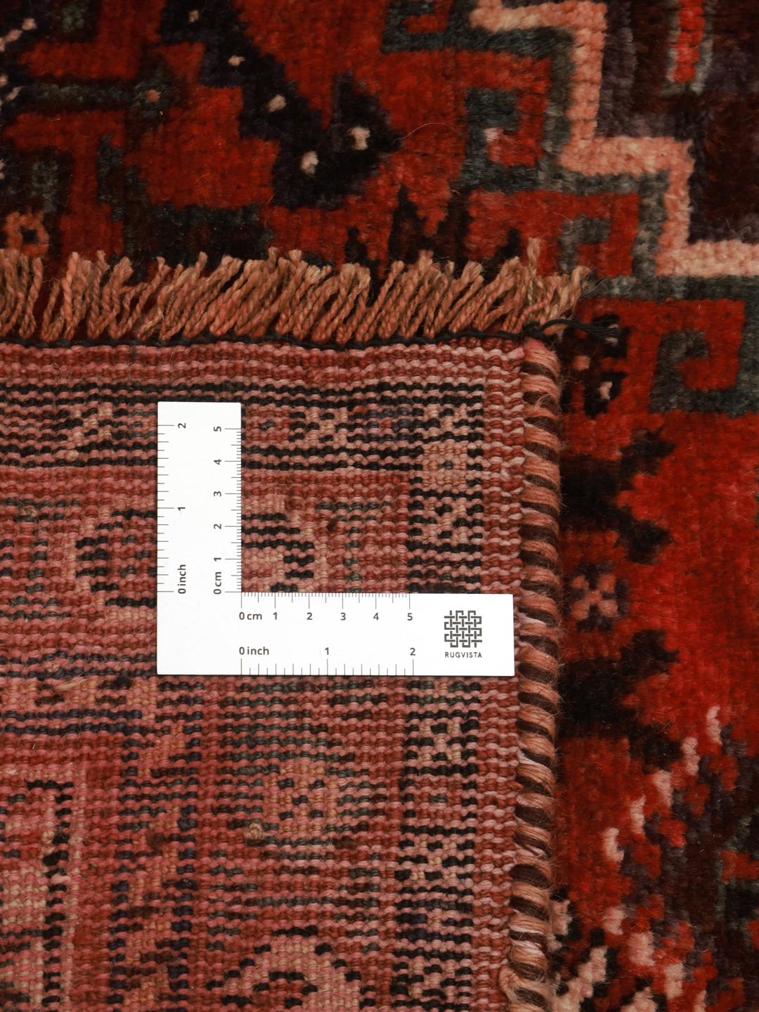 A hand-knotted Shiraz rug from the Middle East featuring geometric red patterns.