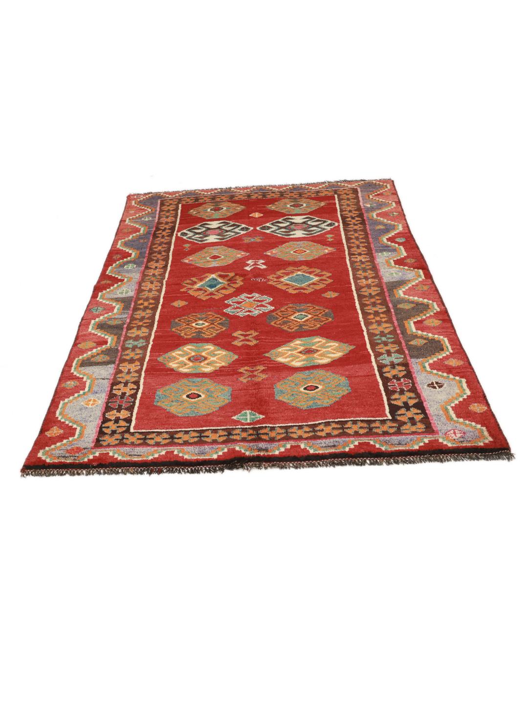 A hand-knotted Ghashghai rug from the Middle East with a vibrant red field and geometric patterns.
