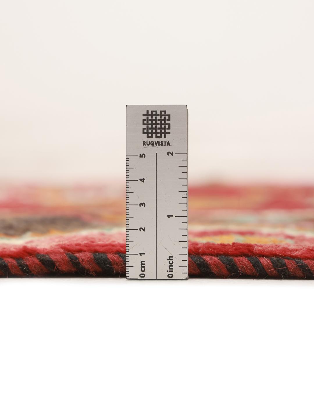 A hand-knotted Ghashghai rug from the Middle East with a vibrant red field and geometric patterns.