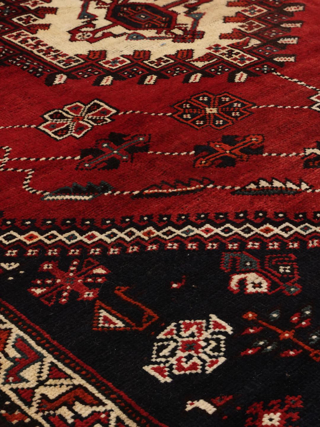 Hand-knotted Middle Eastern rug with red and black geometric patterns