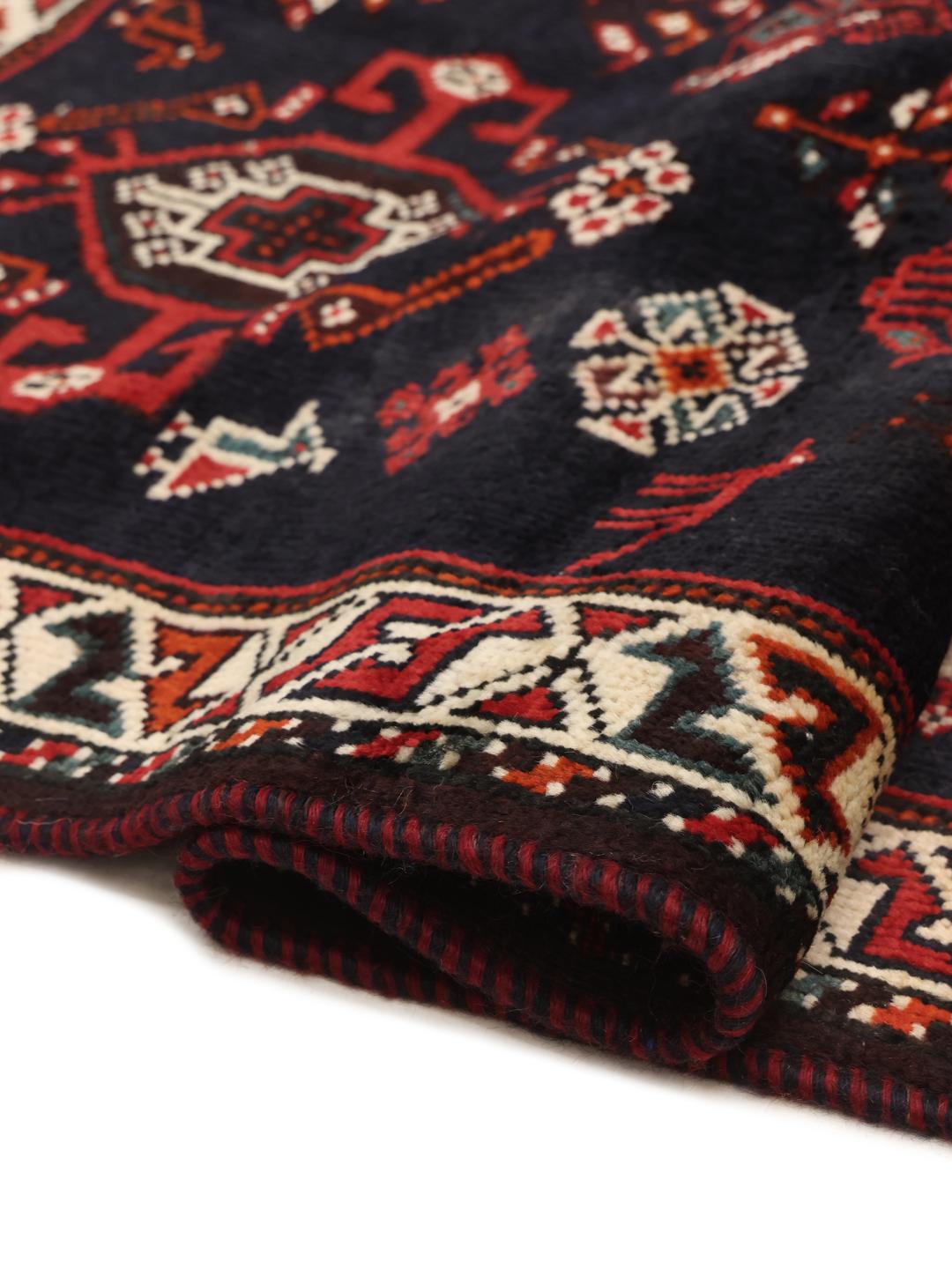 Hand-knotted Middle Eastern rug with red and black geometric patterns