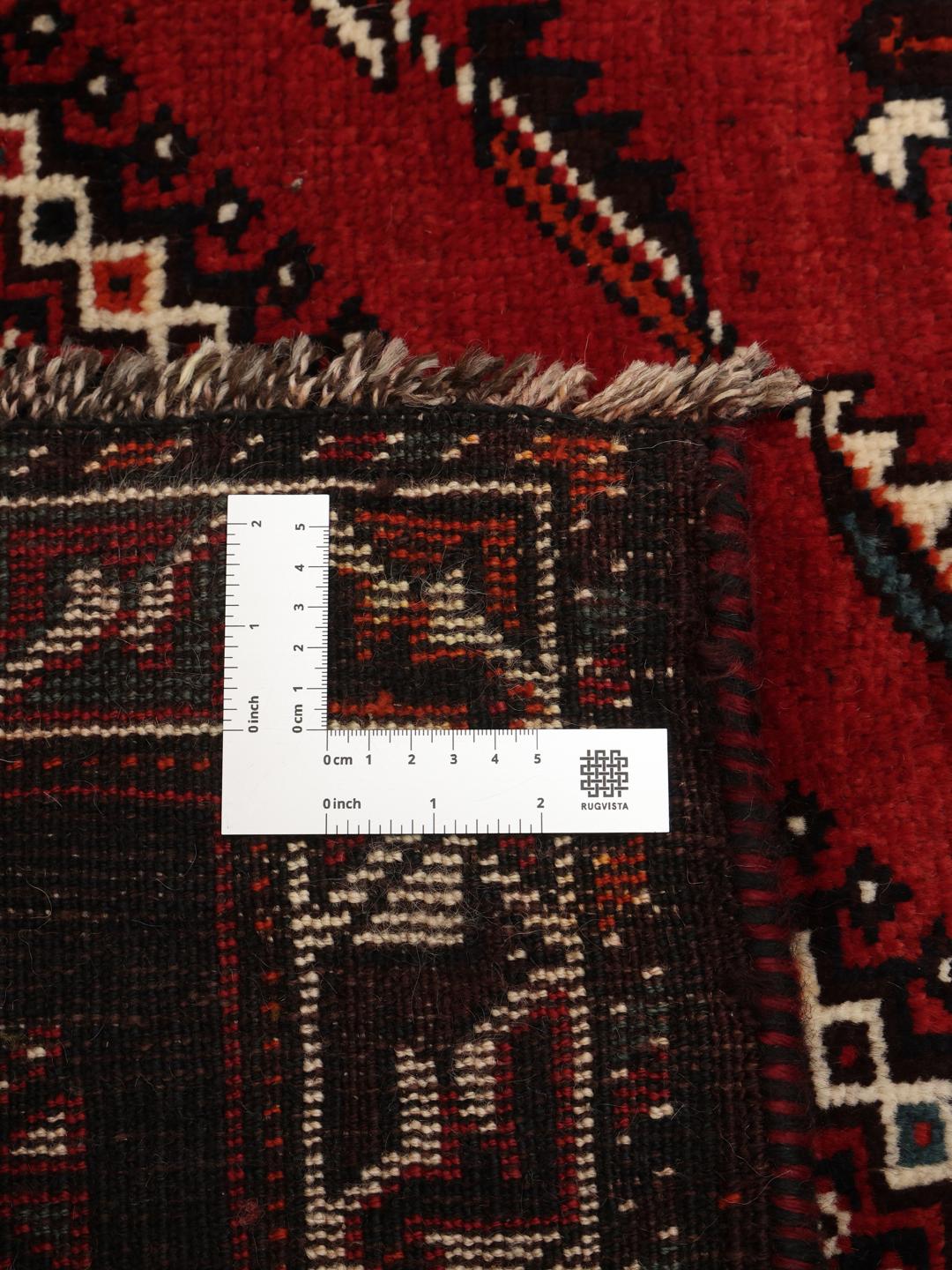 Hand-knotted Middle Eastern rug with red and black geometric patterns