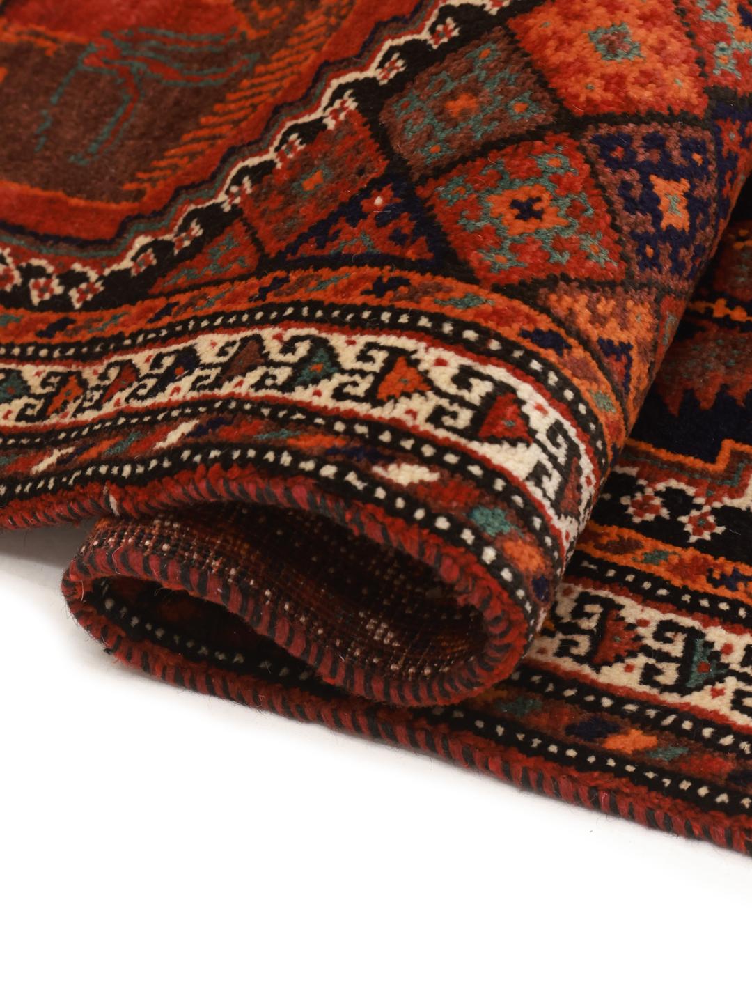 A hand-knotted Qashqai rug from the Middle East featuring a vibrant red and blue geometric pattern.