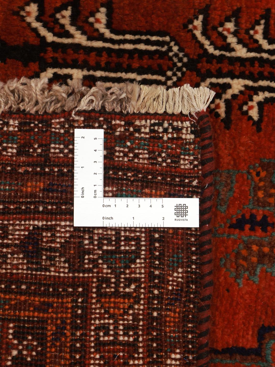 A hand-knotted Qashqai rug from the Middle East featuring a vibrant red and blue geometric pattern.