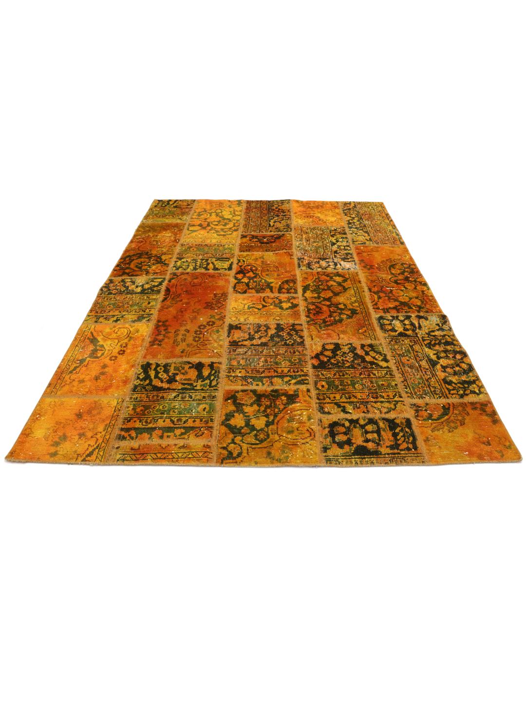 Un tapis patchwork coloré avec des tons orange et vert foncé, présentant des motifs vintage complexes.