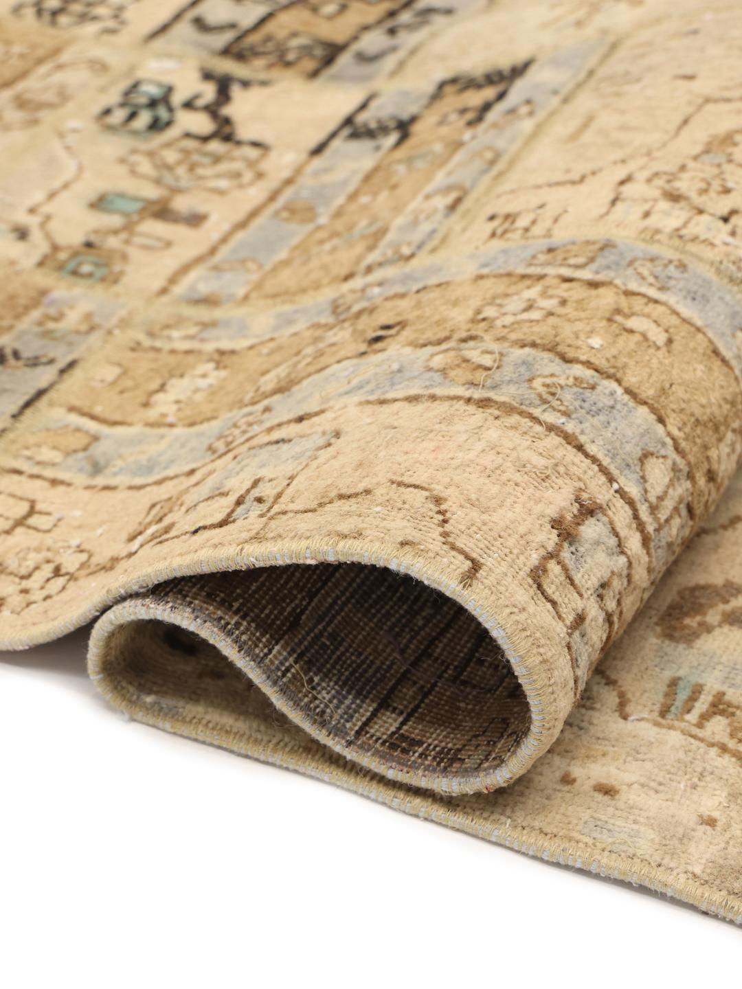 Et unikt patchwork-tæppe med beige, blå og brune toner, der indeholder indviklede geometriske mønstre fra Mellemøsten.