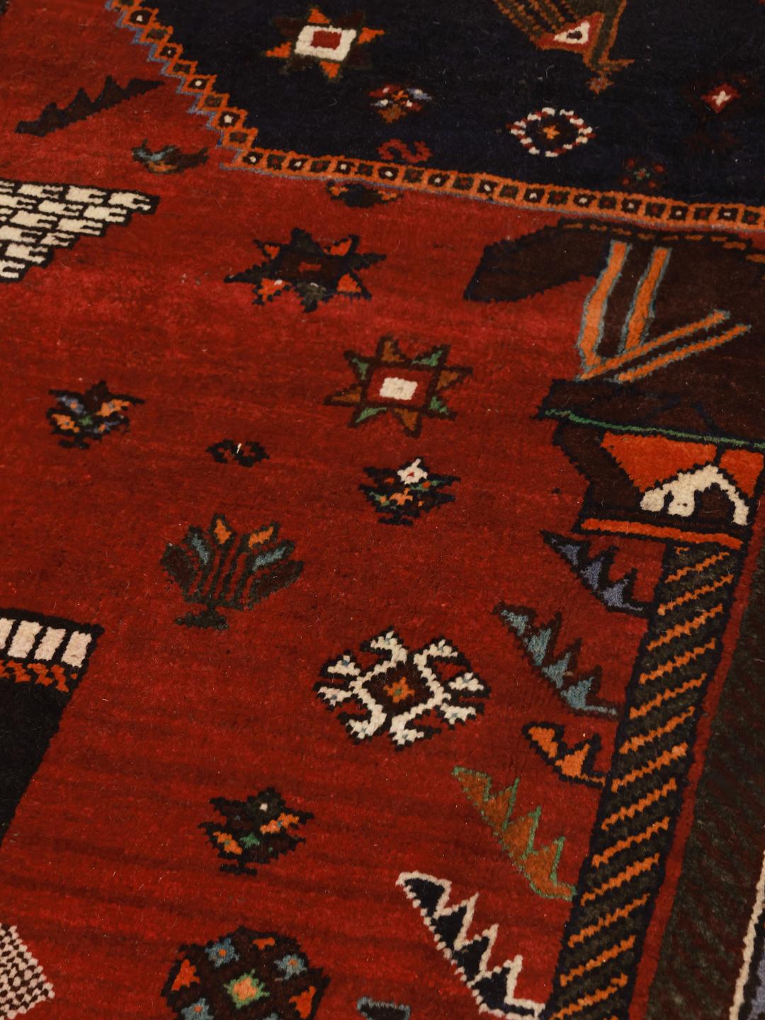 Hand-knotted Ghashghai rug with red field and pictorial motifs