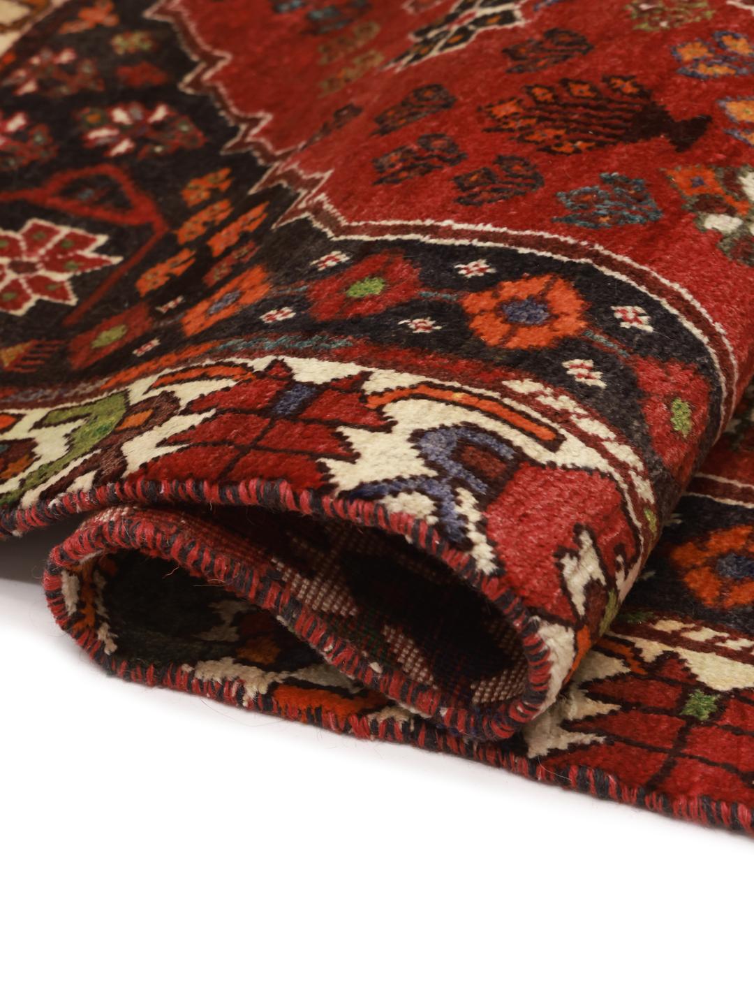 Hand-knotted Shiraz rug from the Middle East featuring a vibrant red and green geometric design.
