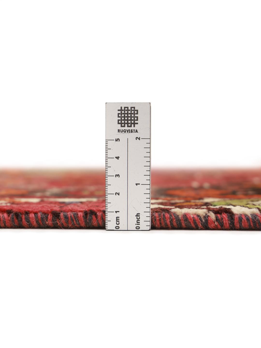 Hand-knotted Shiraz rug from the Middle East featuring a vibrant red and green geometric design.