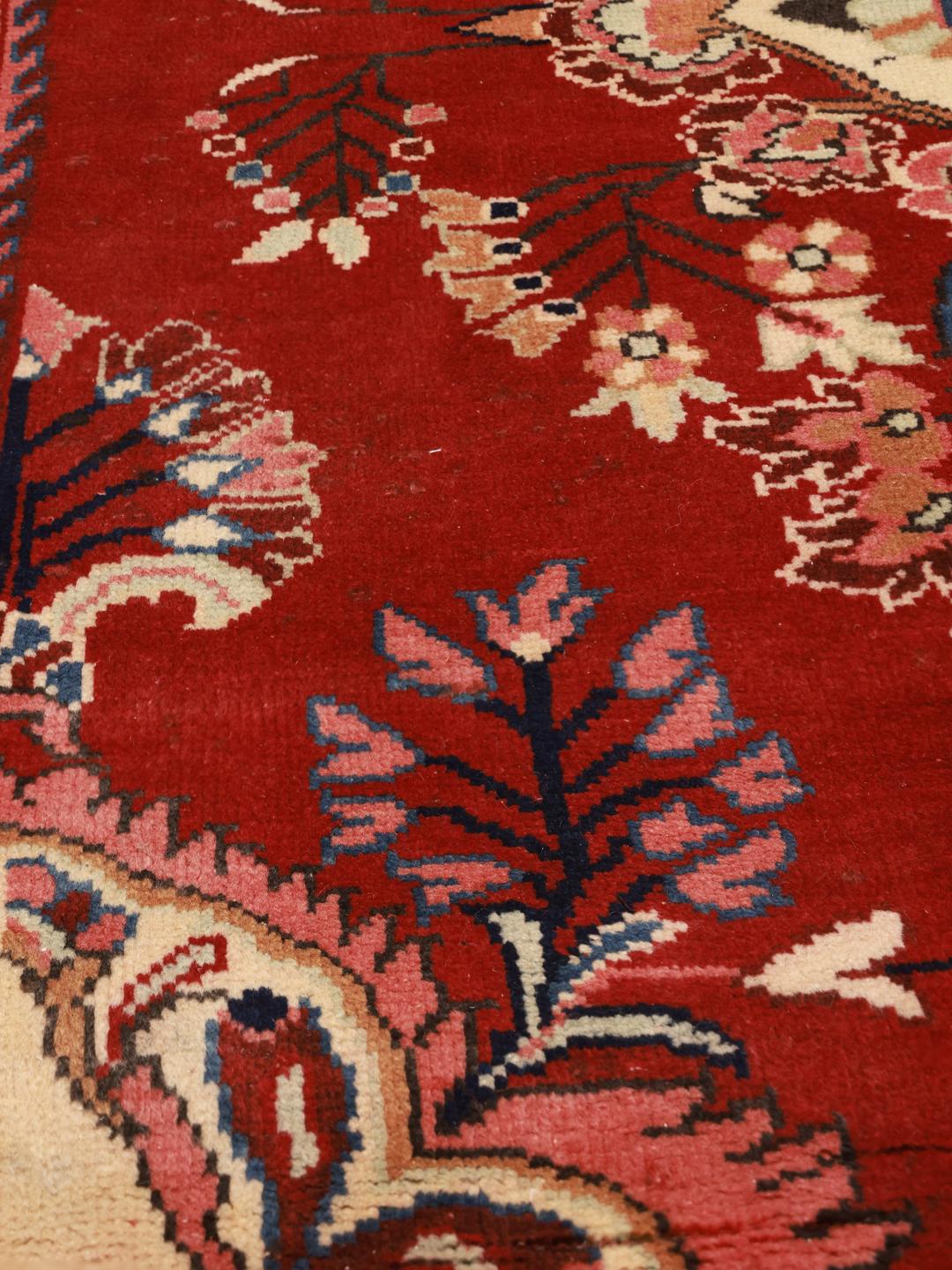 Een handgeknoopt Lillian-tapijt uit het Midden-Oosten in rood met bloemmotieven.