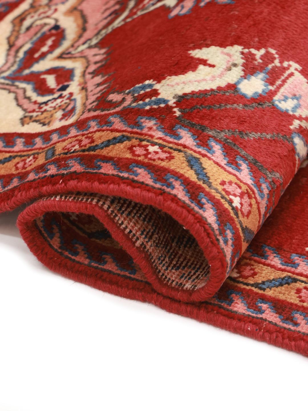 Een handgeknoopt Lillian-tapijt uit het Midden-Oosten in rood met bloemmotieven.