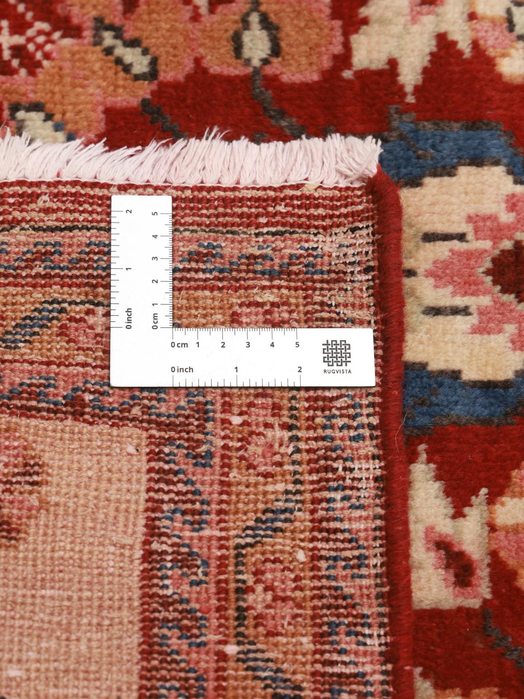Een handgeknoopt Lillian-tapijt uit het Midden-Oosten in rood met bloemmotieven.