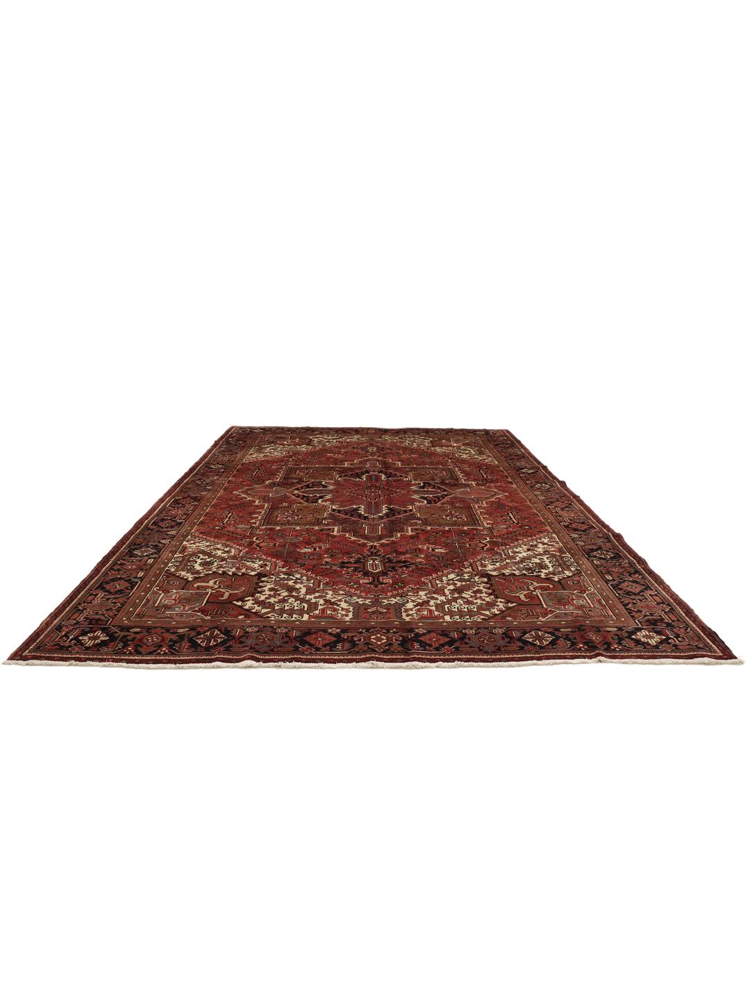 A large, hand-knotted Heriz rug from the Middle East with a red field and geometric medallion.
