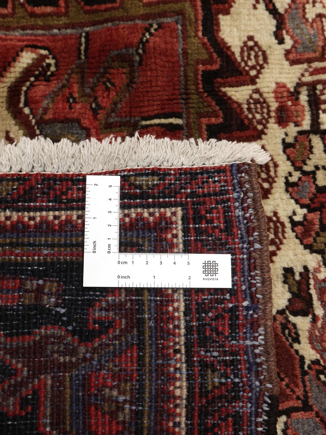A large, hand-knotted Heriz rug from the Middle East with a red field and geometric medallion.