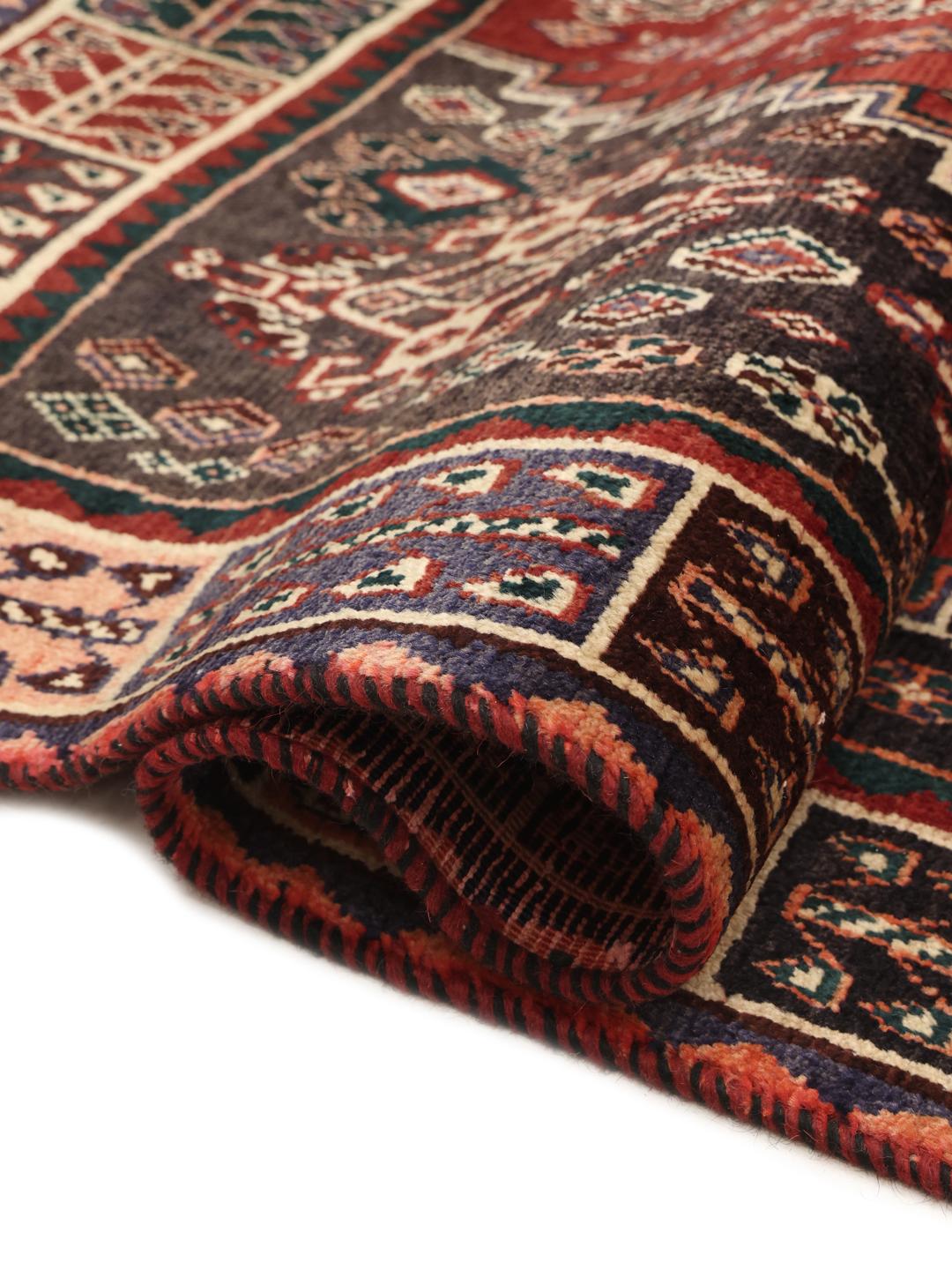 Hand-knotted Ghashghai rug from the Middle East in deep red and black tones