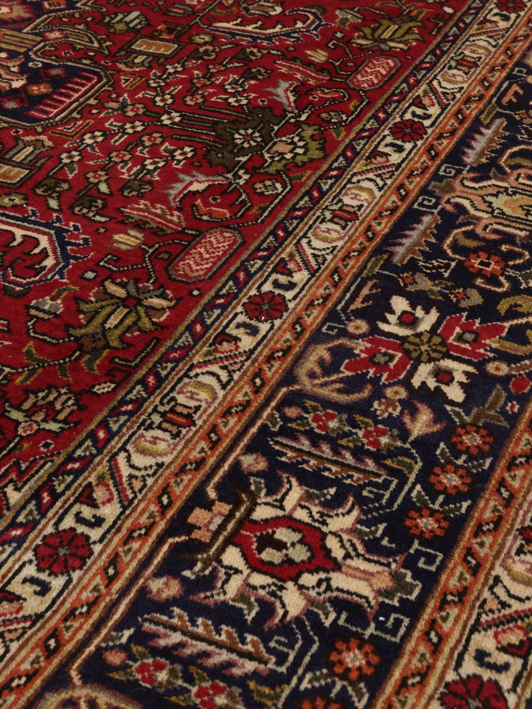 Handmade Tabriz rug from the Middle East featuring a red and blue floral medallion pattern