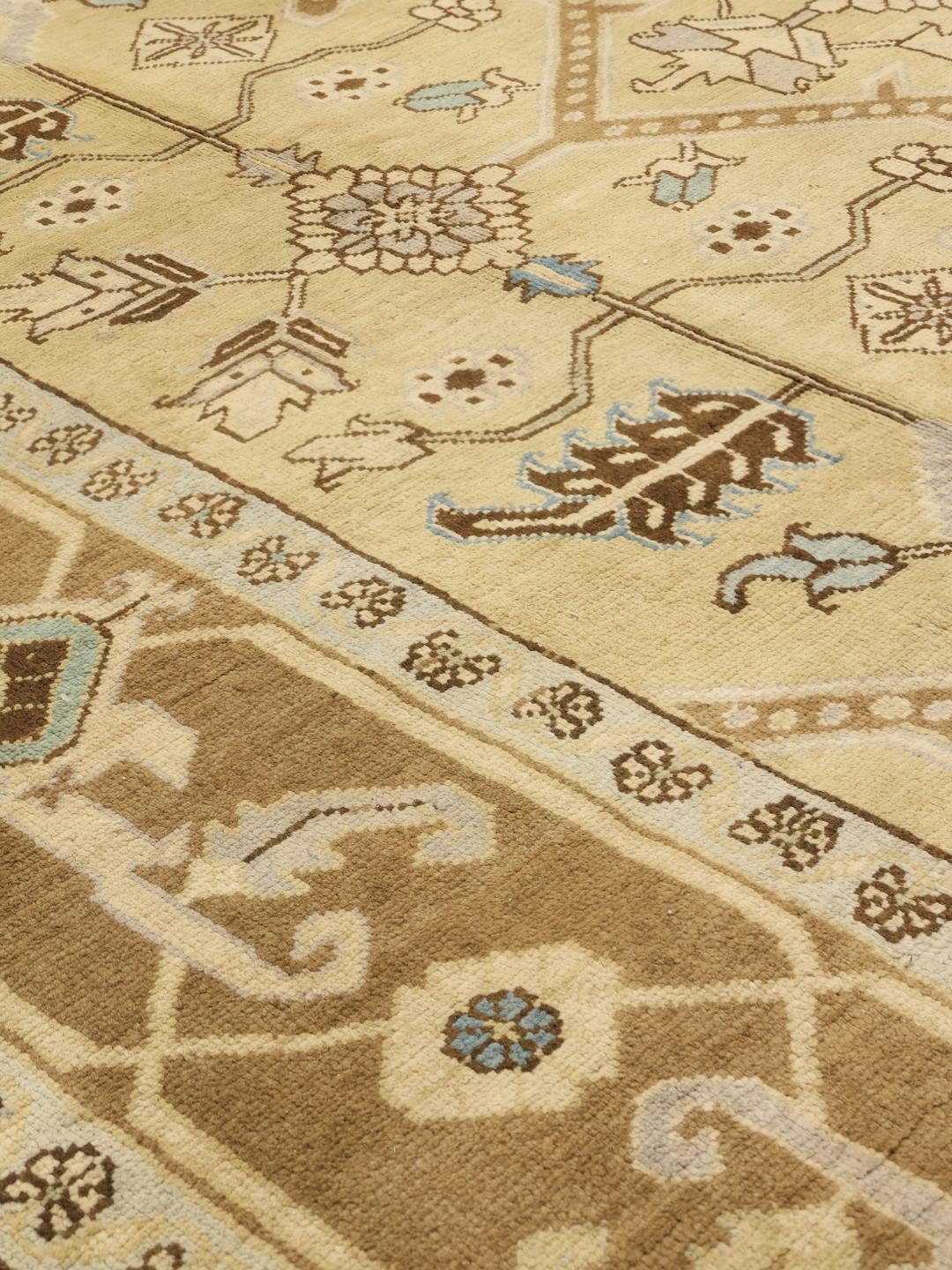 Et håndknyttet Heriz-tæppe fra Mellemøsten med et geometrisk design i beige, blå og brun.