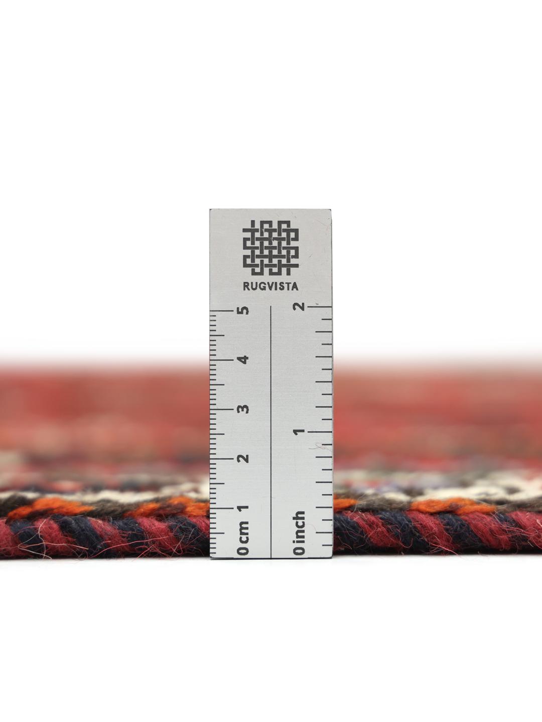 Hand-knotted Qashqai rug with vibrant red and dark tones, originating from the Middle East.