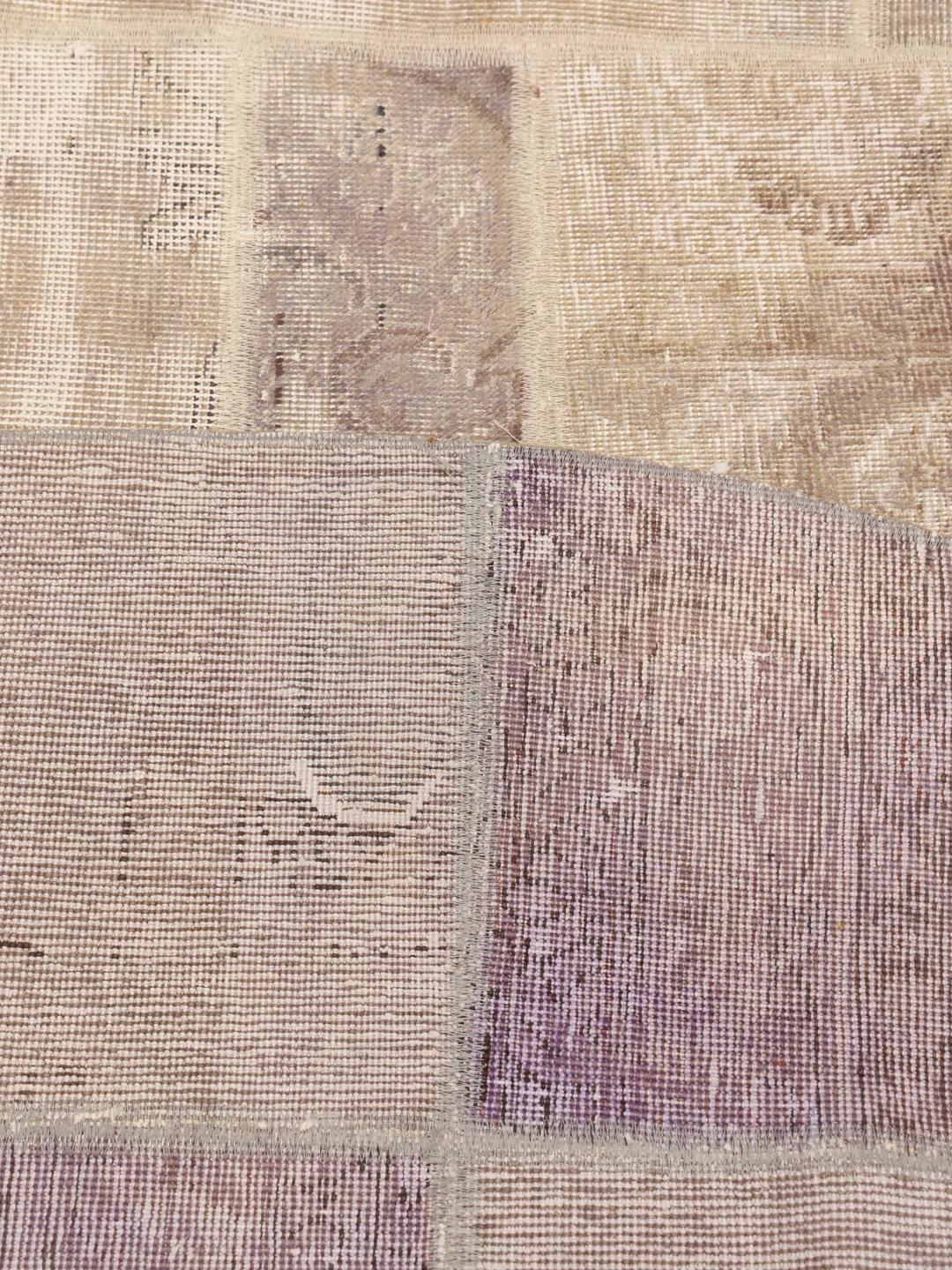 Rundt patchwork-tæppe med indviklede falmede mønstre i beige og dæmpede toner