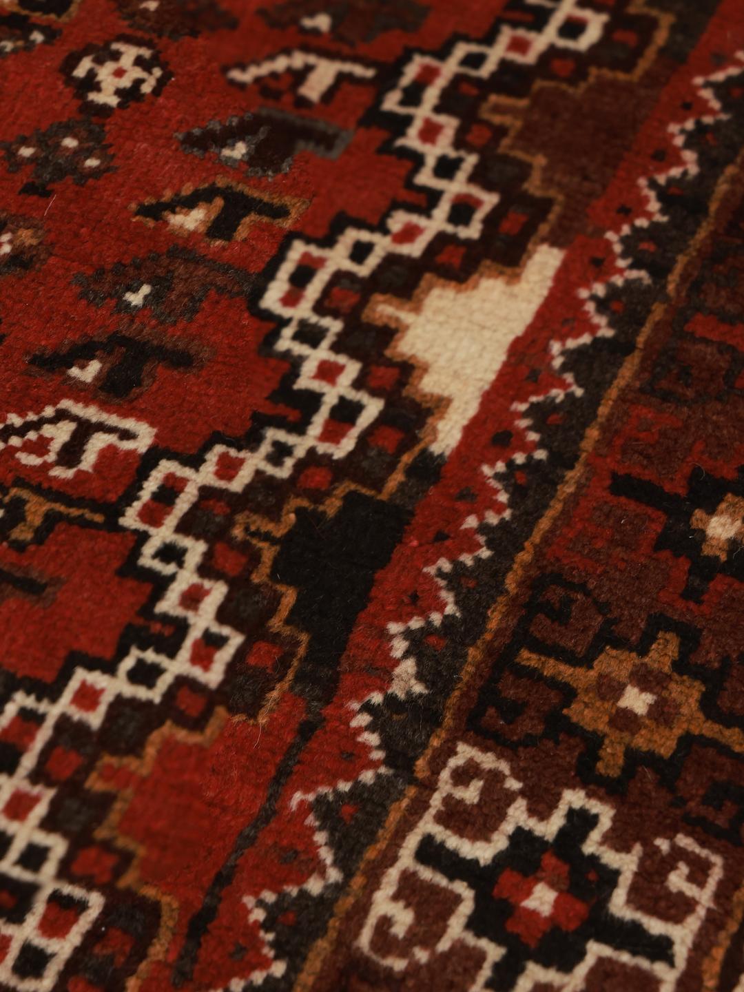 Hand-knotted Ghashghai rug from the Middle East featuring a vibrant red and black palette