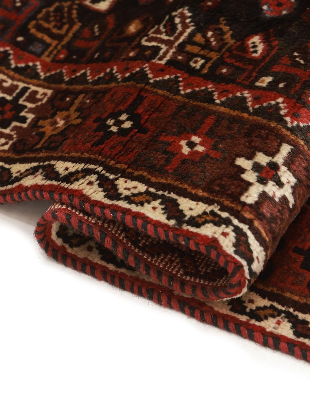 Hand-knotted Ghashghai rug from the Middle East featuring a vibrant red and black palette