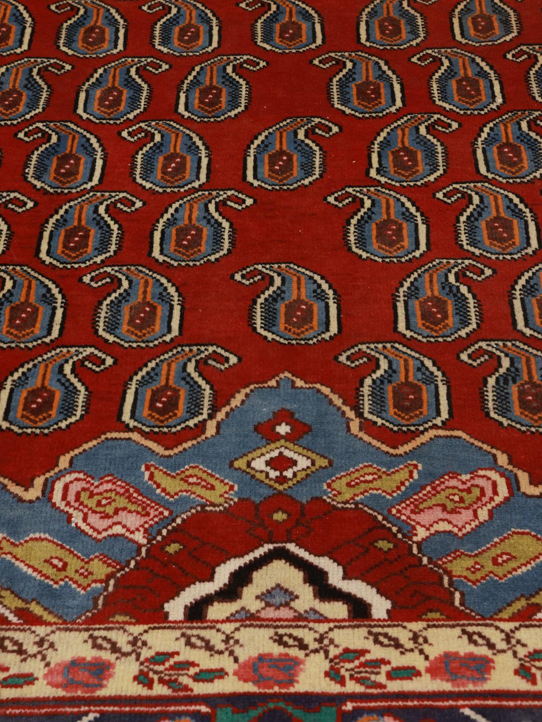 A hand-knotted Tabriz rug from the Middle East with a red field and boteh pattern