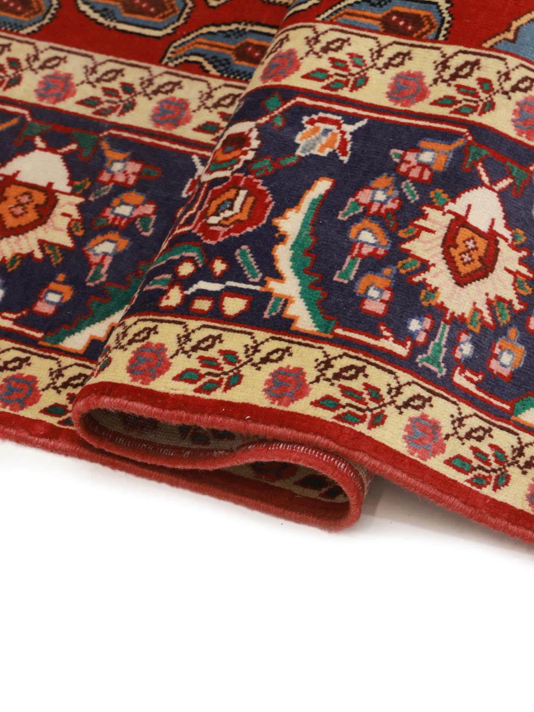 A hand-knotted Tabriz rug from the Middle East with a red field and boteh pattern