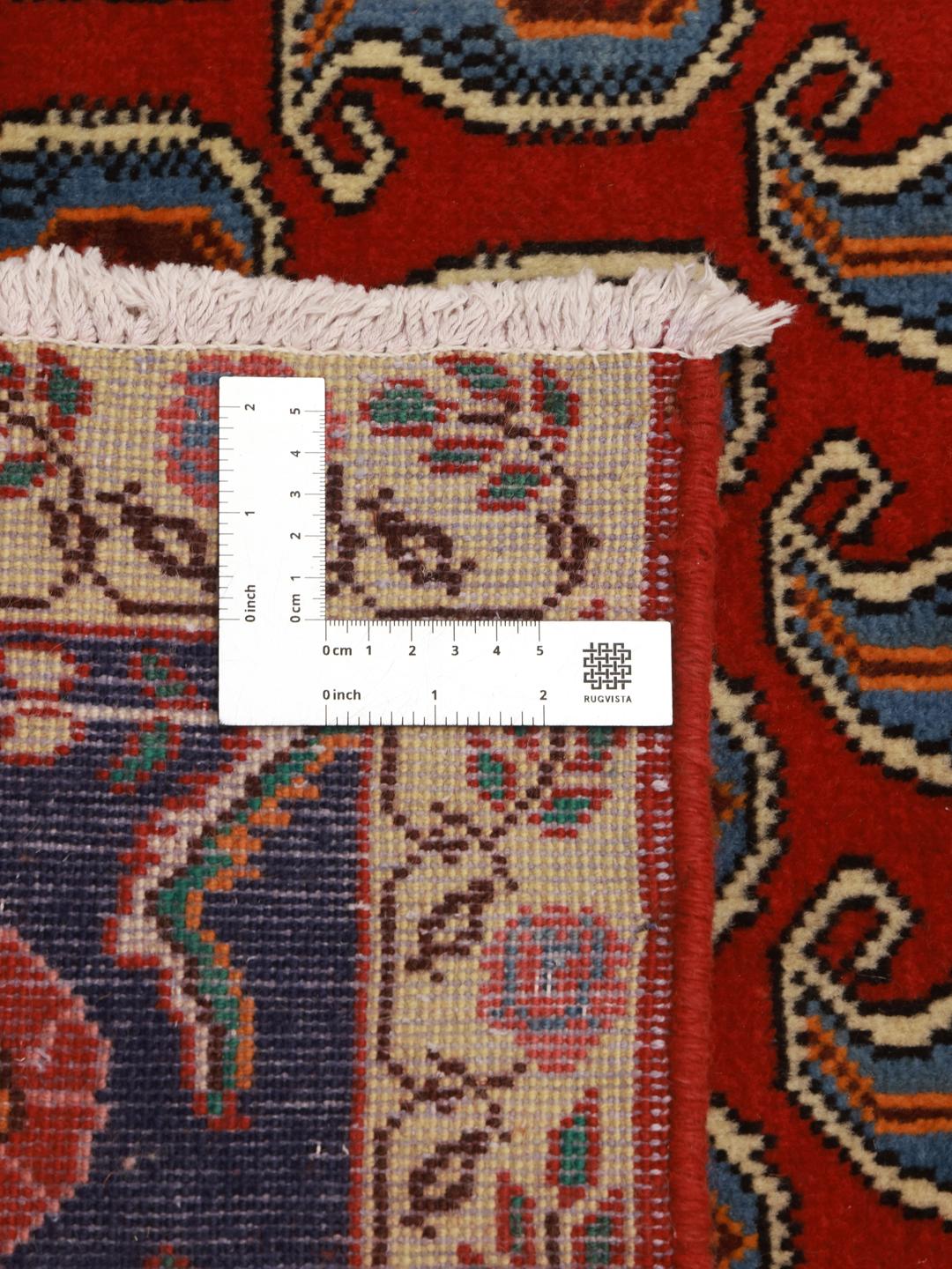 A hand-knotted Tabriz rug from the Middle East with a red field and boteh pattern