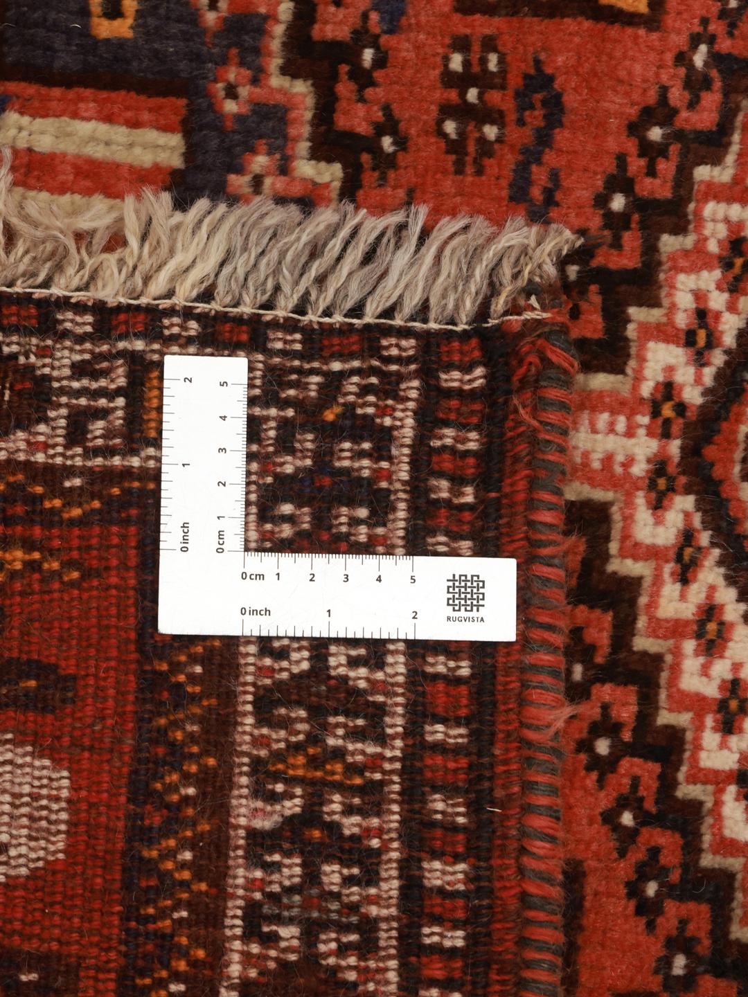 A hand-knotted Shiraz rug from the Middle East featuring a red field with geometric medallions.